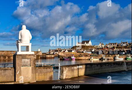 FINDOCHTY MORAY COAST SCOTLAND THE VIEW ACROSS THE HARBOUR FROM THE WHITE MANNIE STATUE WITH FISHING BOATS AND KIRK ON THE HILL Stock Photo