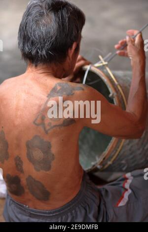 iban old men sitting inside long house weaving a bamboo basket and body with traditional tattoo sarawak borneo 2e9dmfb