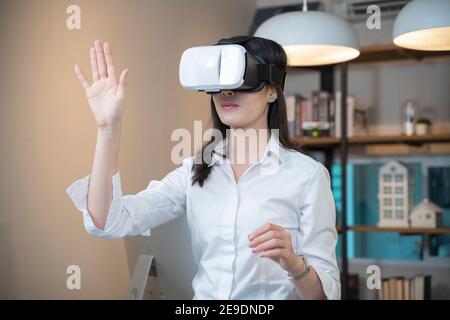 Woman wearing VR glasses in home. Stock Photo