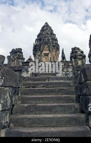 View up stone stairs, lined with imperial lions, towards the central tower of Bakong Temple. Part of Angkor complex, Cambodia. Ancient Khmer temple, h Stock Photo