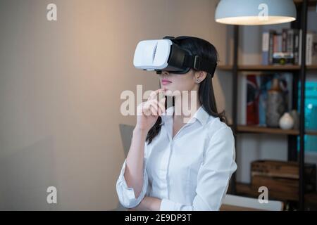 Woman wearing VR glasses in home. Stock Photo