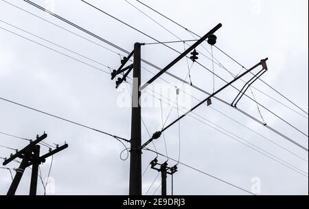 Overhead  railway power lines under cloudy sky background Stock Photo