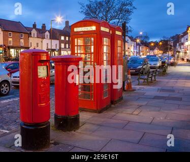 Evening view of the red phone boxes and post boxes on Yarm High Street in North Yorkshire Stock Photo