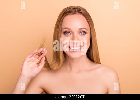 Close-up view portrait of nice attractive cheerful girl holding in hand damaged thin weak ends keratin silk effect smoothing nourishing vitamin Stock Photo