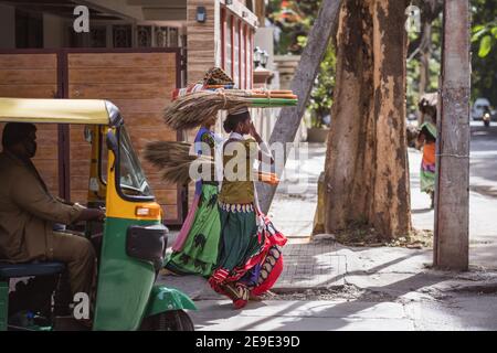 Bengaluru, India - June 08, 2020. Indian women in colorful sarees carrying a bundle on her head. India, Bengaluru Stock Photo