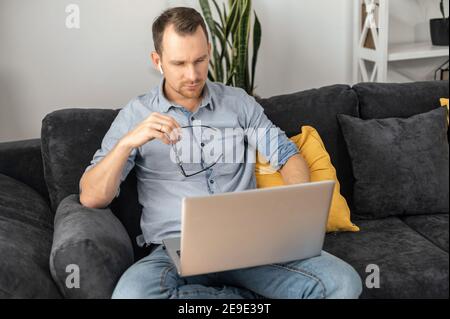 Focused businessman lost in thinks about solving a complex business problem, developing, engineering. A freelancer using laptop for working from home Stock Photo