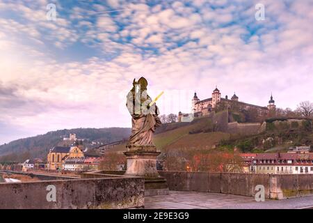 Statue of Saint Kilian on Old Main Bridge, Alte Mainbrucke, with Fortress Marienberg in the background, Wurzburg, Bavaria, Germany Stock Photo