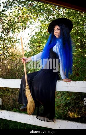 Naked Black Halloween Witch on a Broom Stick Flying Past the Moon Stock
