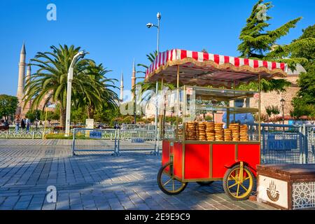 Man sale traditional Turkish bagel simit from cart on the summer Istanbul street. Turkey , Istanbul - 21.07.2020 Stock Photo