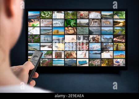 Person holds remote control. VoD content provider concept. Television streaming video concept. Media TV video on demand technology. Online Video servi Stock Photo