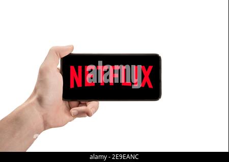USA, NEW YORK February 2, 2021: Close up of phone with NETFLIX logo in man Hand. horizontal position. Netflix is a well known global provider of strea Stock Photo
