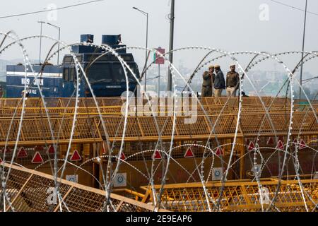 Security personnel seen behind concertina wire and several layers of barricading at Ghazipur border, during the demonstration.Farmers protests continue for the 70th day as police seal the border with Barbed wire and concrete wall after the Republic day violence. Stock Photo