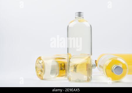 Transparent plastic bottle with water surround lying bottles with yellow liquid on white background, mockup, copy save. Stock Photo