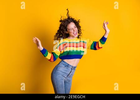 Photo of childish funky lady wearing casual colorful sweater dancing closed eyes isolated yellow color background Stock Photo