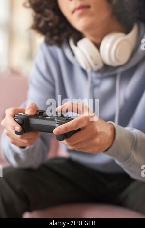 Close-up of guy in headphones holding joystick playing computer video games in the room Stock Photo