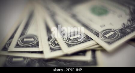 Blurry background with one-dollar bills.  A wad of dollars. Stock Photo
