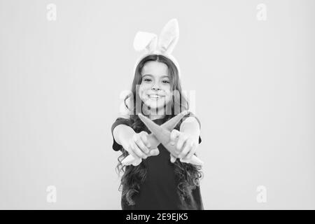 Having a healthy breakfast. good for your teeth. Nibbles carrot like hare. kid in rabbit ears eating carrot. child bunny costume with carrot. little happy girl food for rabbits. healthy childhood. Stock Photo