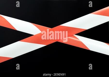 Red and white lines of barrier warning tape forbids passage. No entry concept Stock Photo