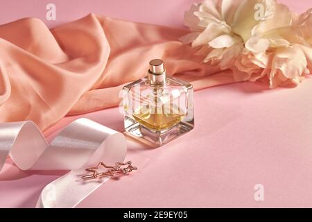 A perfume bottle on a pink background with crumpeled fabric, white satin  ribbon and star shape hair pin. Spring theme Stock Photo - Alamy