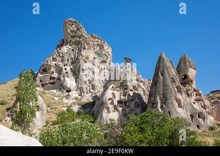 Fairy chimneys and homes / dwellings carved into the soft rock in Uçhisar, Cappadocia, Nevşehir Province in Central Anatolia, Turkey Stock Photo