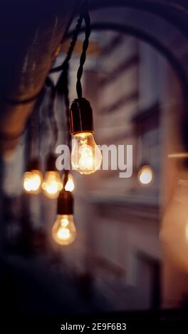 Lighting from a garland of incandescent lamps in the evening. Stock Photo