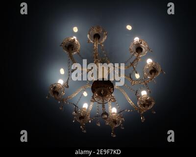 Modern electric bulbs shines in ceiling lustre in old classic style Stock Photo