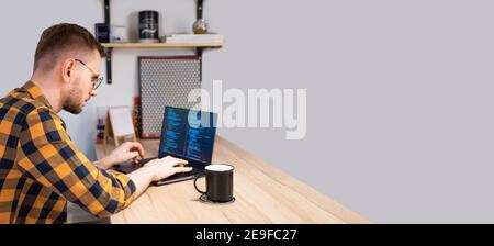 Portrait of male programmer using Programs computer code in a bright Home. Concept programmer Day Stock Photo