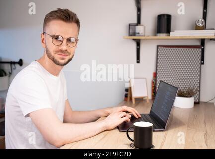 Portrait of male programmer using Programs computer code in a bright Home. Concept programmer Day Stock Photo