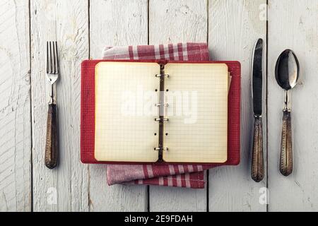 Vintage Empty Cookbook on Wooden Table with Old Silverware Stock Photo