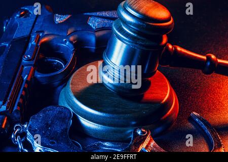 Gun and judge's gavel on the table. Crime, robbery, attack concept Stock Photo