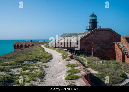 Old black lighthouse on a rooftop of old military fort in Florida. Ocean horizon in the background. Fort Jefferson. Stock Photo