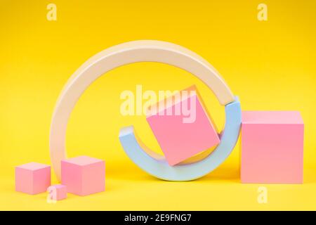 Wooden geometric shapes forms colorful figures composition on yellow background Stock Photo