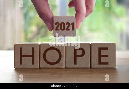 Hope wooden blocks with hand holding 2021 Stock Photo