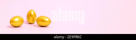 Easter eggs decorated with gold paint on a pink background Stock Photo