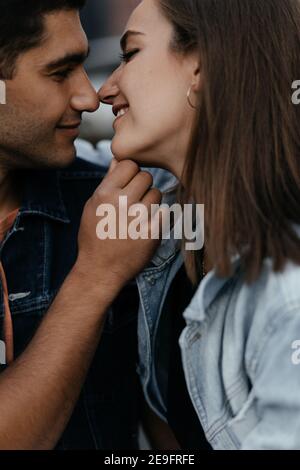 Happy young couple in love dressed in casual style kissing with their noses and smiling. Couple in love in the city. Urban lovestory Stock Photo