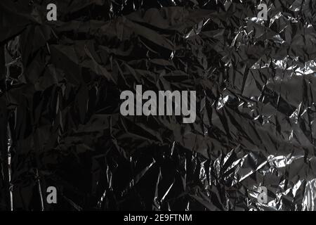 Real transparent plastic wrap on black background. Disposable film for overlay and composition in design. Thin polymer foil layer from packaging Stock Photo