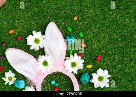 Colored eggs and vibrant candies on grass. Easter composition Stock Photo