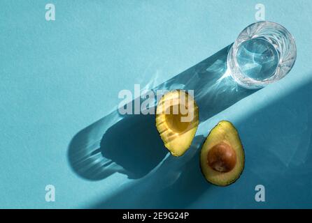 4 halved avocados sit on a cute cow-shaped wooden cutting board. A bowl of  fresh cucumbers sits in background. Dinner at home Stock Photo - Alamy