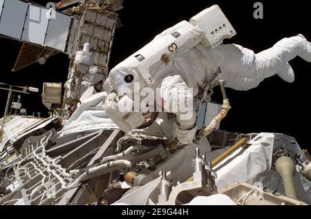 Astronaut Joseph R Tanner waves toward the camera during a space walk ...