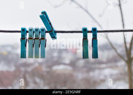Clothes pegs on the wire with ice on them - Winter time concept. Stock Photo