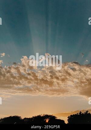 Dramatic sunset rays through cloudy dark sky over the ocean Stock Photo ...
