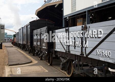 Goods train wagons / carriages being shunted by World War II era diesel and steam loco trains (one at either end) at Chatham Historic Dockyard, Chatham. Kent. UK. (121) Stock Photo