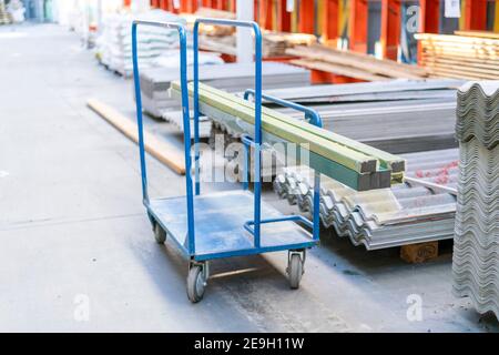 Trolley in a hardware store with building materials. Warehouse large storage. Shopping trolley cart Trolley in a hardware store loaded with building Stock Photo