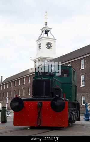Diesel locomotive train engine named Rochester Castle in front of the Clocktower Building of the Old Naval Store House at Chatham Historic Dockyard, Kent England UK (121) Stock Photo