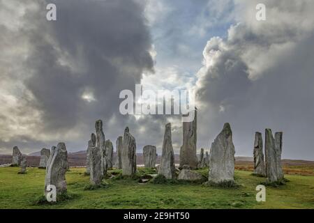 Isle of Lewis and Harris, Scotland: Hooded crow on the tallest stone with clearing storm clouds at the Callanish Standing Stones Stock Photo