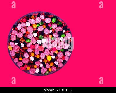 dry sugary fruit-nut mix on glassy dish isolated on pink Stock Photo