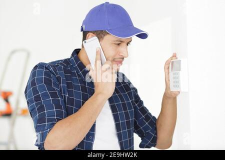 young electrician installing alarm system Stock Photo