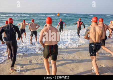 Alabama Gulf of Mexico Coast Florabama Mullet Man Triathlon,competitors swimmers running into surf water men male, Stock Photo