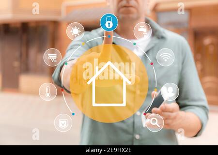 Man using application of smart home automation outdoors Stock Photo