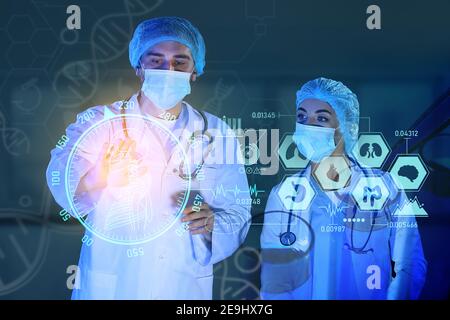 Young scientists using virtual screen on dark background Stock Photo